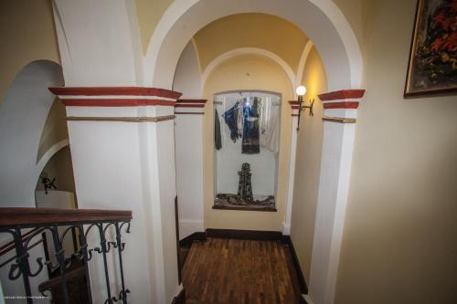 a hallway with white walls and an archway with a staircase at Hotel Sighişoara in Sighişoara