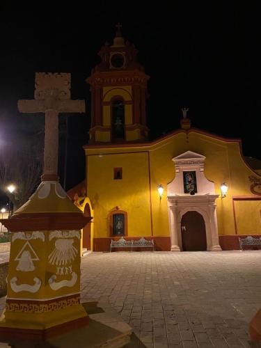 a church with a cross in front of it at night at Hotel Boutique Santo Cuervo in Bernal