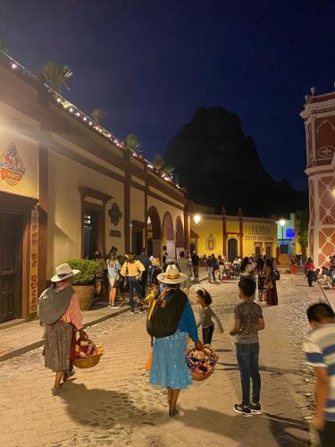 a group of people walking down a street at night at Hotel Boutique Santo Cuervo in Bernal