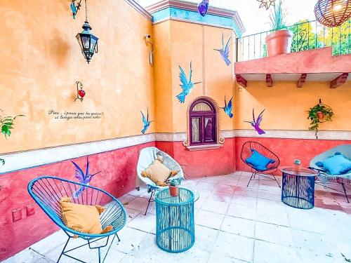 a painting of a patio with chairs and tables at Hotel Boutique Santo Cuervo in Bernal