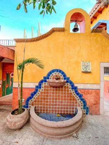 a fountain in front of a building with a palm tree at Hotel Boutique Santo Cuervo in Bernal