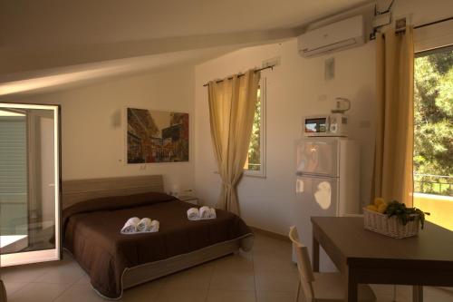 a bedroom with a bed and a table and a refrigerator at Villa Santa Barbara in Cefalù