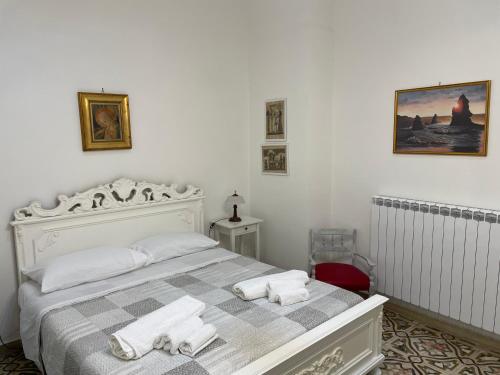 una camera da letto bianca con un letto e asciugamani di Paladini holiday a Lizzanello