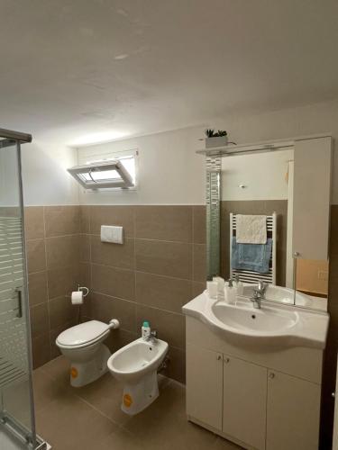 bagno con lavandino, servizi igienici e specchio di Paladini holiday a Lizzanello