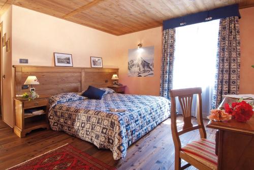 a bedroom with a bed and a desk and a window at Miramonti in Valtournenche