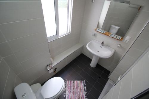 a bathroom with a white toilet and a sink at Olympia Hotel in Sarandë