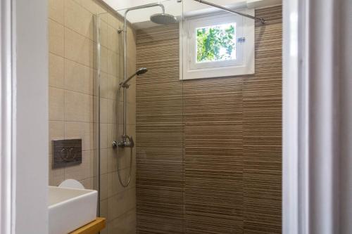 a bathroom with a shower and a sink at Terracotta beach house in Lefkímmi