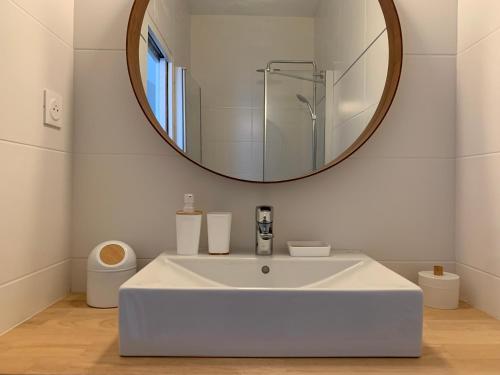 La salle de bains est pourvue d'un lavabo blanc et d'un miroir. dans l'établissement TY STUDIOS Hyper Centre Ville, à Brest