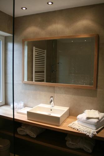 a bathroom with a white sink and a mirror at B&B La Chambre d'à Côté in Aische-en-Refail