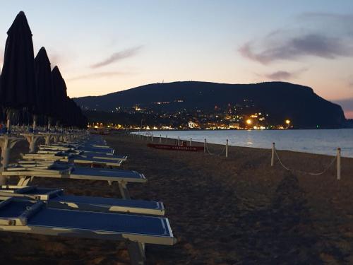 a row of lounge chairs on a beach at sunset at La Dolce Vita in Castelfidardo