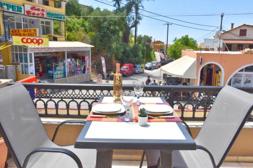 a table and chairs sitting on a balcony at Mike's apartments in Agios Gordios
