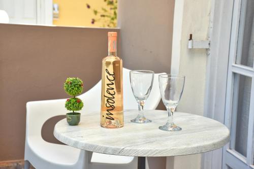 a bottle of wine and two glasses on a table at Mike's apartments in Agios Gordios