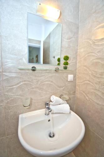 a white sink in a bathroom with a mirror at Mike's apartments in Agios Gordios