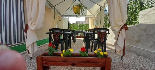 a restaurant with chairs and a table with flowers at Lilium in LʼAquila