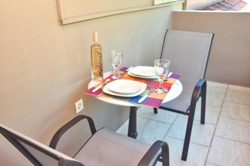 a table with plates and glasses on top of it at Mike's apartments in Agios Gordios