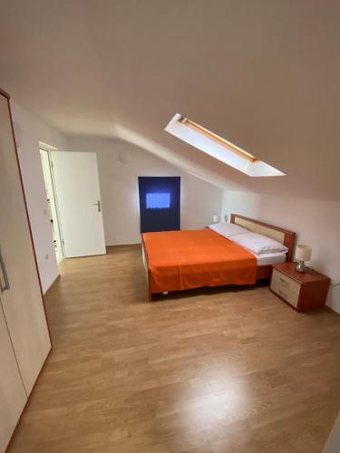 1 dormitorio con cama con colcha de color naranja en Apartman S&D Rogoznica, en Rogoznica