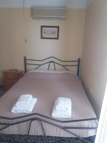 a bedroom with a bed with two towels on it at To Kyma-Afoi Roussou in Rovies