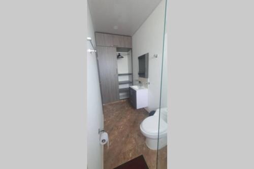 a bathroom with a toilet and a sink at Quinta SHADDAI MELGAR in Melgar