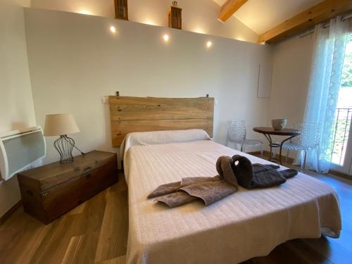 a bedroom with a bed with a robe on it at A MANDRIA, appartements avec cuisine 30m2, patio, vue Montagnes et citadelle, 5 minutes à pied du centre ville et des rivières in Corte