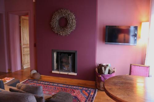 sala de estar con chimenea y mesa en B&B La Chambre d'à Côté en Aische-en-Refail