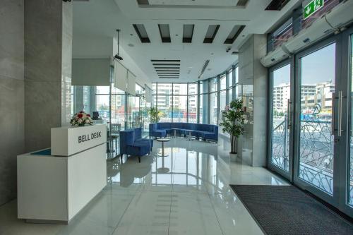 an office with a lobby with blue chairs and windows at City Avenue Al Reqqa Hotel in Dubai