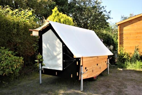 a black and white dog house with a white roof at StrandGutkoje auf dem Campingplatz Strandgut in Cuxhaven