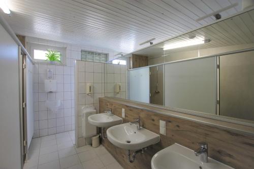 łazienka z 2 umywalkami i dużym lustrem w obiekcie StrandGutkoje auf dem Campingplatz Strandgut w mieście Cuxhaven