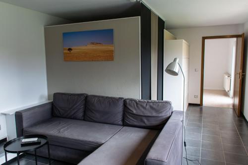 a living room with a couch and a picture on the wall at Ferienwohnung Untersteinbach in Pfedelbach