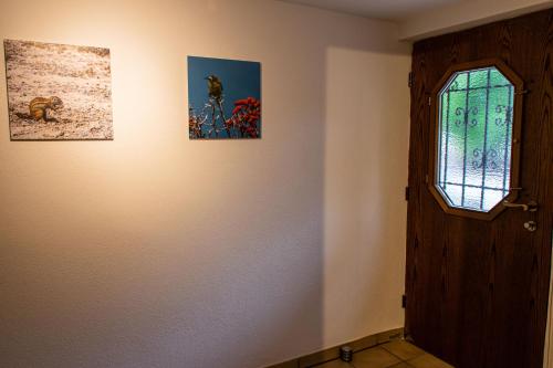 a room with two pictures on the wall and a door at Ferienwohnung Untersteinbach in Pfedelbach