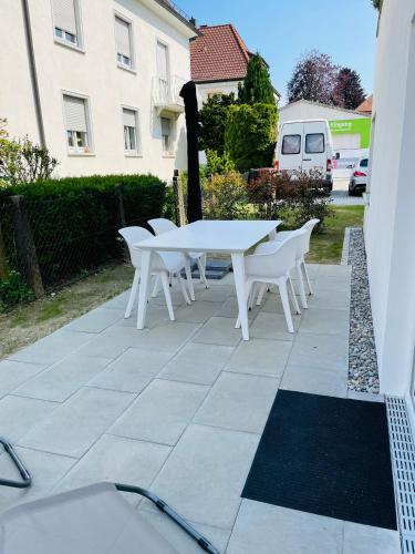 a white table and white chairs on a patio at Seeschilf Apartments in Friedrichshafen in Friedrichshafen