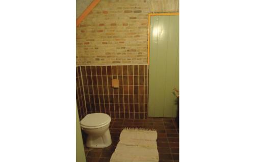 uma casa de banho com um WC e uma parede de tijolos em 2 Bedroom Awesome Home In Surhuizum em Surhuizum