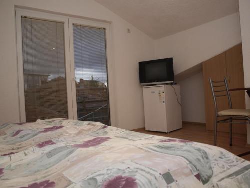 a bedroom with a bed and a television and a window at Bogdanoski Studios & Guest Rooms in Ohrid