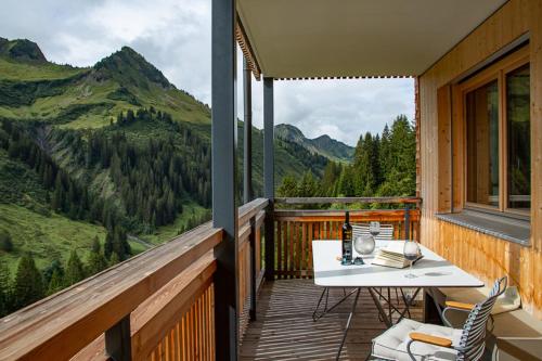 a balcony with a table and chairs and a view of mountains at Ferienwohnung Smart Living in Damuls