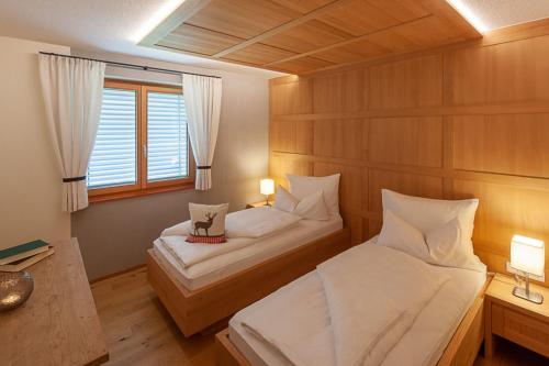 1 dormitorio con 2 camas y ventana en Ferienwohnung Smart Living, en Damüls