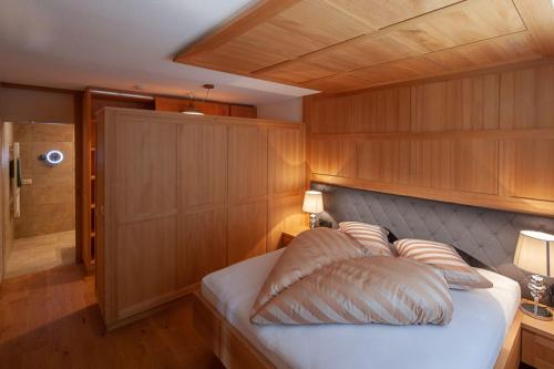 a bedroom with a bed with a wooden wall at Ferienwohnung Smart Living in Damuls