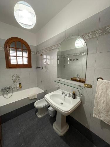 a bathroom with a sink and a toilet and a mirror at Casa di Rosaria - Due appartamenti nel centro storico con giardino sul terrazzo in Depressa