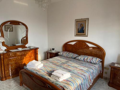 ein Schlafzimmer mit einem Bett mit einer Kommode und einem Spiegel in der Unterkunft Casa di Rosaria - Due appartamenti nel centro storico con giardino sul terrazzo in Depressa