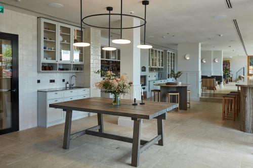 a kitchen with a wooden table with flowers on it at RUNO Hotel Porvoo in Porvoo