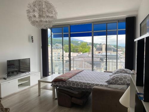 een slaapkamer met een bed en een groot raam bij Studio moderne et lumineux centre ville Aix les Bains in Aix-les-Bains