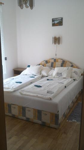a bedroom with a large bed with white sheets and pillows at Balatonpart-lak in Balatonfenyves