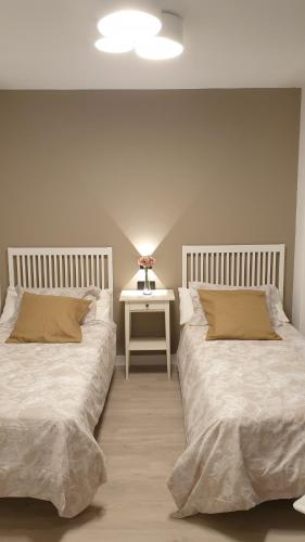 sypialnia z 2 łóżkami i stolik nocny w obiekcie Apartment Pontus Stellae w Santiago de Compostela