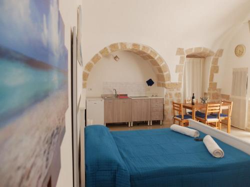 ein Wohnzimmer mit einem blauen Bett und eine Küche in der Unterkunft Levante House in Polignano a Mare