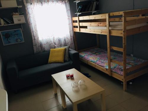 a living room with a couch and a bunk bed at Artist Cottage in Dromolaxia in Larnaka