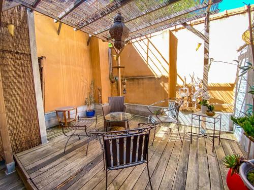 a patio with chairs and tables on a wooden deck at Hotel Relais Du Postillon in Antibes