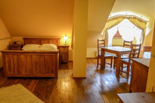 um quarto com uma cama, uma mesa e cadeiras em Karczma Regionalna Hotel GOŚCINNA CHATA em Wysowa-Zdrój