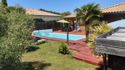 une cour arrière avec une piscine et une maison dans l'établissement VILLA avec piscine chauffée, à Moliets-et-Maa
