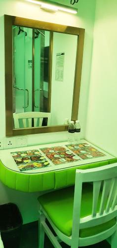 a bathroom with a green counter and a mirror at iOtel Luxury Kiosk Hotel in Angeles