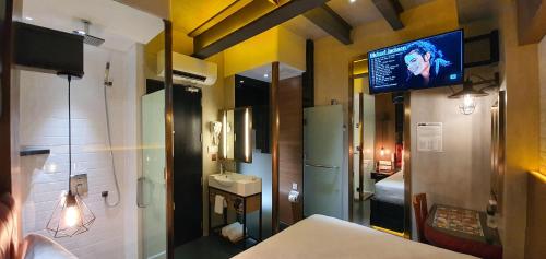 Habitación con TV y baño con lavabo. en iOtel Luxury Kiosk Hotel, en Ángeles