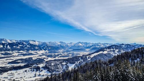 a view of a snow covered mountain range with trees at Landhaus am Schneewittchenberg in Sonthofen