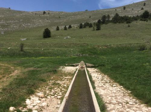 a dirt road in a field with a grassy hill at da sciuri case vacanza Barisciano in Barisciano